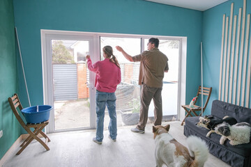 couple cleaning windows and doors glass at home