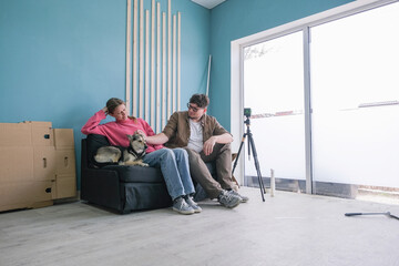 a couple toning windows glass at home using toning film, sitting on the sofa looking at the job