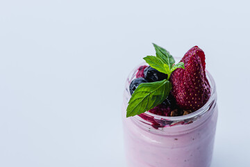 Fresh berry yogurt parfait served in a glass jar with mint on top
