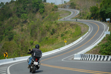 Fototapeta premium motorcycle on the road rides away. Travel on vacation, enjoy the nature trail. motorcycle in a sunny motorbike on the road riding.with sunset light. copyspace for your individual text..