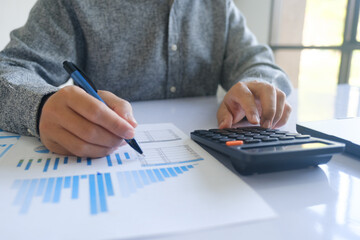 Close up accountant banker or bookkeeper making calculations with calculator.