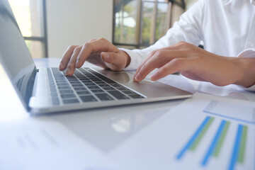 Professional businessman using computer laptop analyzing financial graphs investment marketing data.