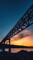 Silhouetted steel bridge spanning a tranquil waterway at sunset.