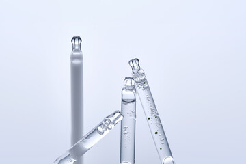 Four different droppers with facial serum in a row.