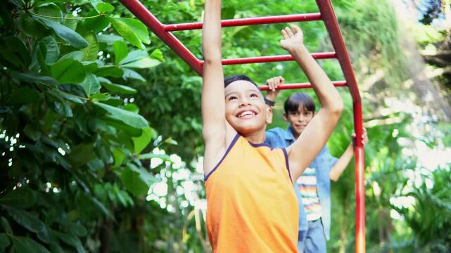 Young boy having fun on monkey bars in park