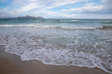 Mediterranean beach on the island of Majorca, or Mallorca on Balearic Sea, are part of Spain. Island in the Mediterranean Sea. Seaside vacations, clouds, seascape. View of the sea and the island.  