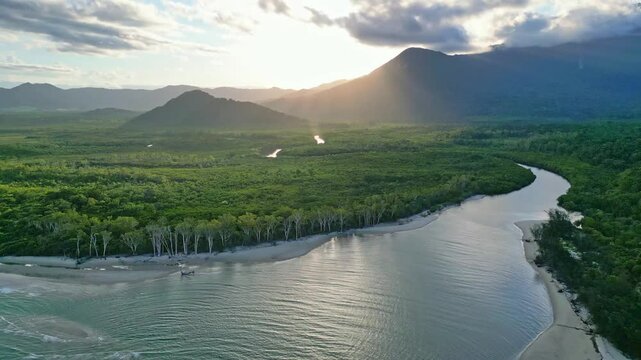 Aerial of beautiful tropical rainforest with mountains and river at sunset