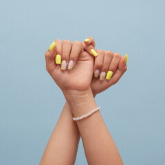 Yellow-nailed fingers gently crossing as a sign of hope, faith, or promise..Color harmony and composition blend calm energy and expressive motion...