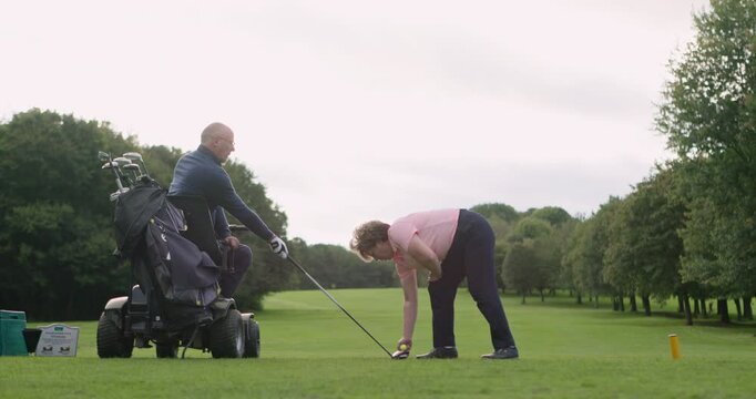 Senior man, woman and coaching for golf, sport and target with teaching on mobility scooter on grass. Elderly person with disability, mentor or game for fitness, rehabilitation or exercise on green