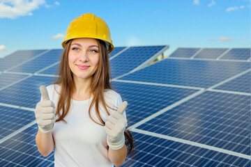 Woman Technician in Yellow Hard Hat, White Shirt, Gloves Giving Thumbs Up at Solar Farm Under Blue...