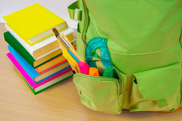 School books and backpack on a desk. Teenage style, learning concept.