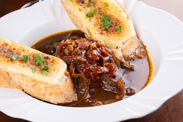 Irish onion soup dish served with baguette bread with cheese au gratin close-up
