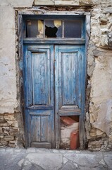 Old wooden door with heavy wear, cracked and faded paint, and rusty metal details. Perfect for vintage, rustic, or abandoned-themed projects.
