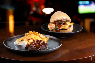 plate of mignon with wine sauce and potatoes and meat sandwich with grilled cheese and blurred...