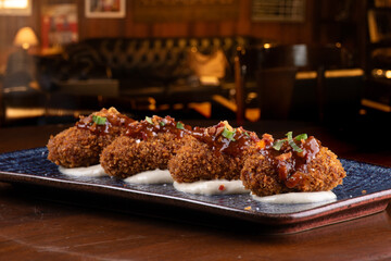 portion of mini croquettes with 4 units on parmesan cream blurred background