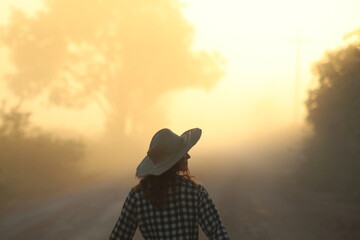 silhueta de mulher caminhando em estrada iluminada pelo nascer do sol. foto tirada na rodovia...