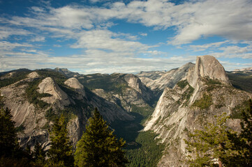 View of the iconic landmark mountain Half Dome and surrounding peaks in Yosemite National Park as viewed from Glacier Point.