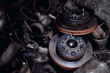 The original brake discs on the car were removed to upgrade them to be better.Old brake discs are piled up in a pile of old iron.