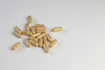 Vitamin capsules with beige powder inside close-up on white background. Biologically active additives