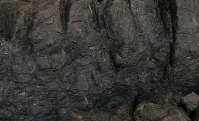 Dark, textured rock surface with varied patterns