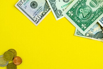 Dollars and euro coins on a yellow background, background with copy space.