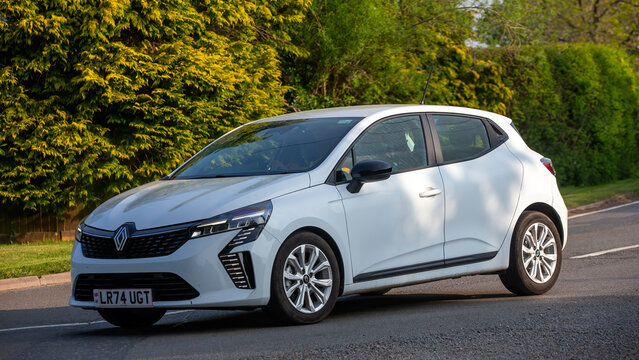 Whittlebury,Northants.,.UK - April 27th 2025:   2024 white Renault Clio hybrid electric car driving on an English country road.