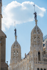Ornate spire with a statue of a medieval knight holding a flag on the roof of Matthias Church in...