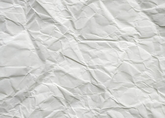 Obraz premium Crumpled white paper texture on a clean, blank surface, featuring wrinkles against a white background.