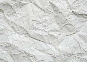 Obraz premium Crumpled white paper texture on a clean, blank surface, featuring wrinkles against a white background.
