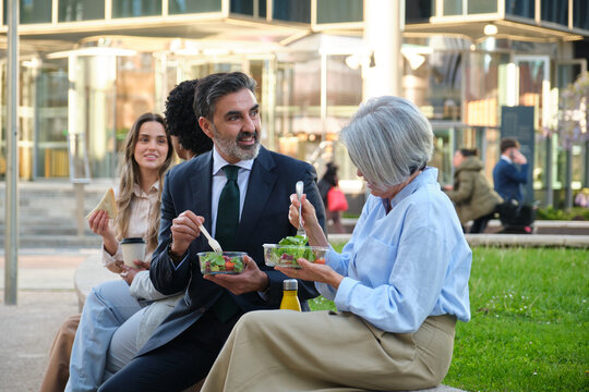Multi ethnic business team enjoying a healthy lunch break together outdoors - Powered by Adobe