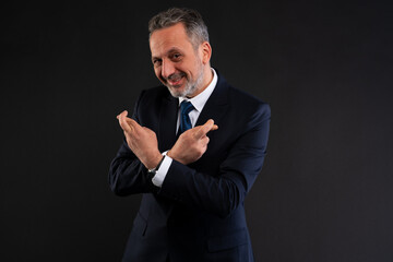 Businessman crossing fingers on both hands for luck.