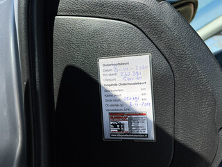 Vehicle Mitsubishi Lancer maintenance sticker on car door showing next servicing date and mileage