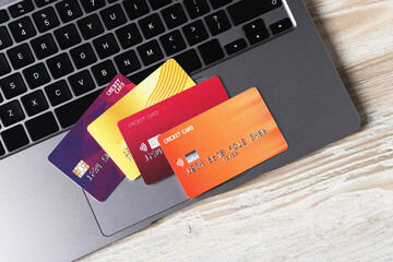 Online payment. Credit cards and laptop on grey wooden table, top view