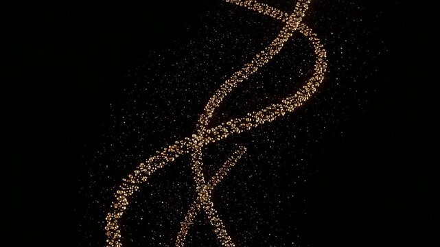 Metallic particles swirling in slow spirals on a dark background  