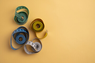 Multicolored measuring tapes on background. Tool for measuring length and volume. Tape for...