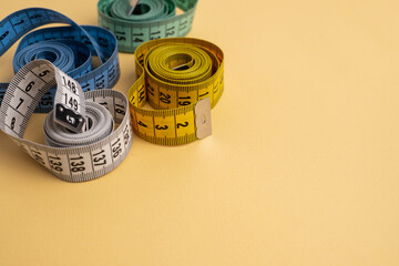 Multicolored measuring tapes on background. Tool for measuring length and volume. Tape for...