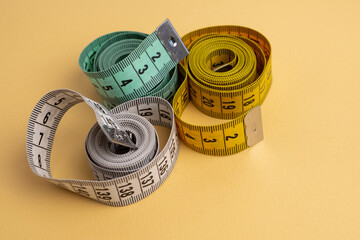 Multicolored measuring tapes on background. Tool for measuring length and volume. Tape for...