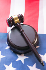 Gavel placed on a base resting an on American flag showcasing patriotism and justice in a courtroom