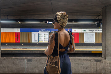 Tattooed mom with baby waiting alone at São Paulo subway station