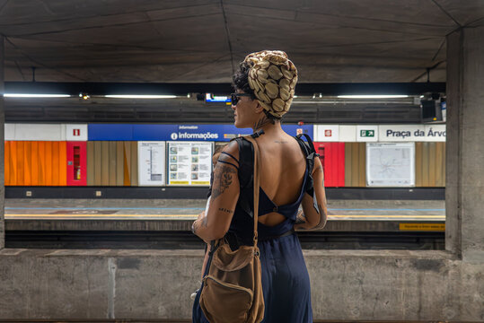 Tattooed mom with baby waiting alone at S&atilde;o Paulo subway station