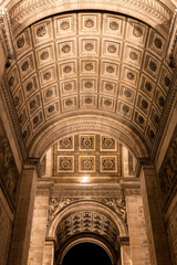 Architectural details of the ornate ceiling at the Arc de Triomphe in Paris during nighttime