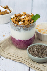 Chia pudding in a glass with berry filling on a light wooden background. Healthy breakfast, healthy lifestyle.