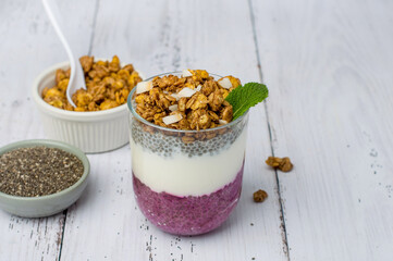 Chia pudding in a glass with berry filling on a light wooden background. Horizontal. Healthy breakfast, healthy lifestyle.