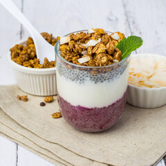 Chia pudding on coconut milk in a glass with berry filling on a light wooden background. Close up. Healthy breakfast, healthy lifestyle.