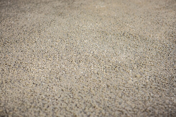 Detailed view of a textured surface made of small, evenly distributed pebbles, likely part of a flooring or underfloor heating construction process.