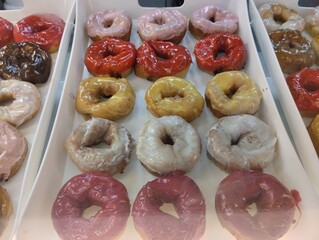 Colored sweet donuts on a tray in a coffee shop bakery. Sweet dishes