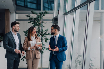 Businesspeople walking and talking in modern office building