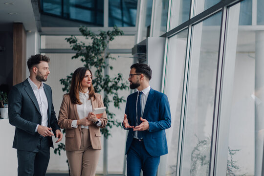Businesspeople walking and talking in modern office building