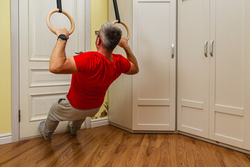 Man doing gymnastic rings workout at home