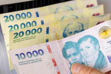 Argentine peso in a money counter. Financial and business concept. 10,000 and 20,000 banknotes,...